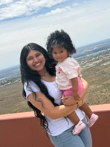 Kassandra Juarez, dental assistant at Apex Dental, holding her daughter outdoors